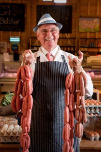 Butcher holding a string of sausages, Quex Barn, Quex Estate, Birchington, Thanet Additional Credit Thanet District Council